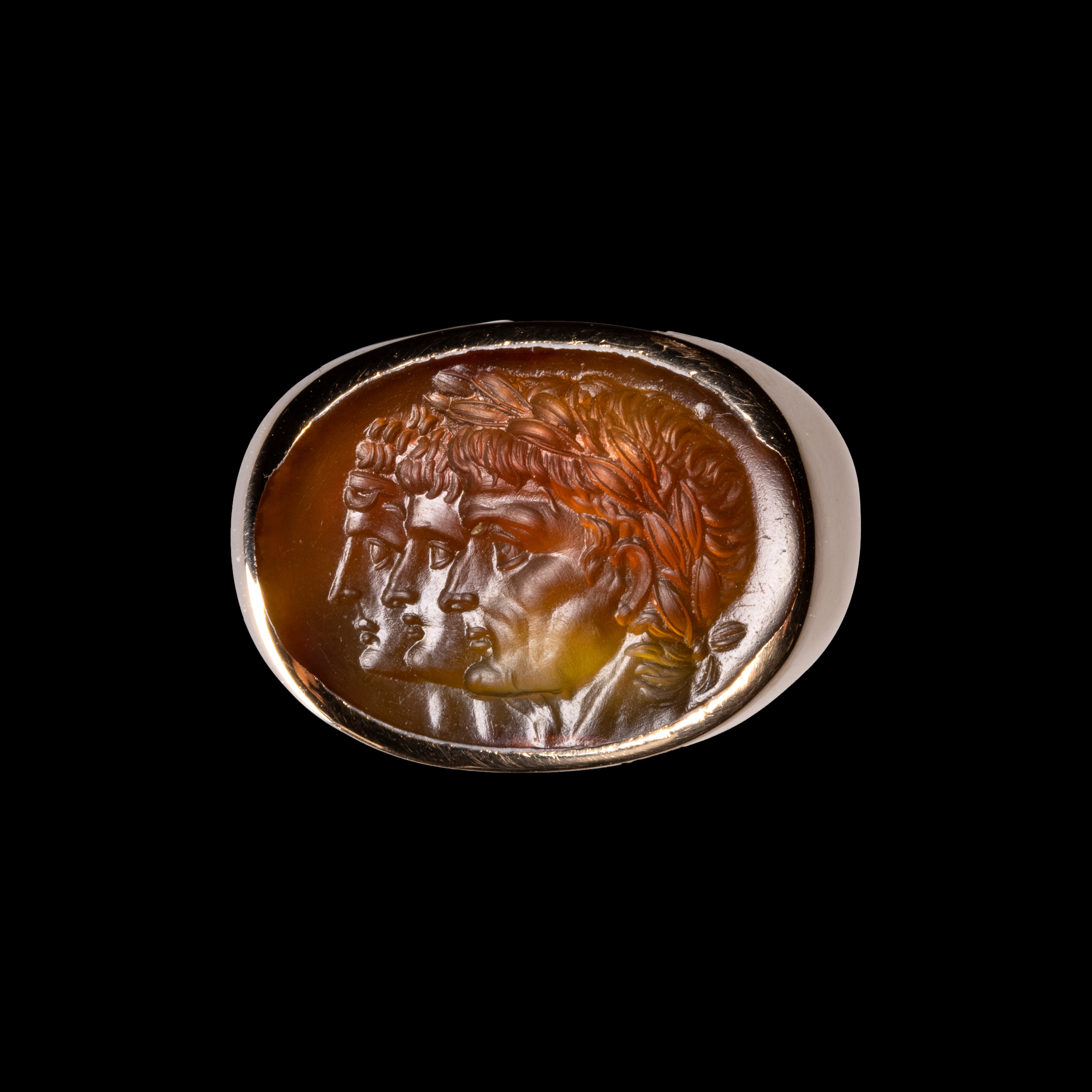 A gold ring with a Neoclassical agate intaglio. Three portraits. 